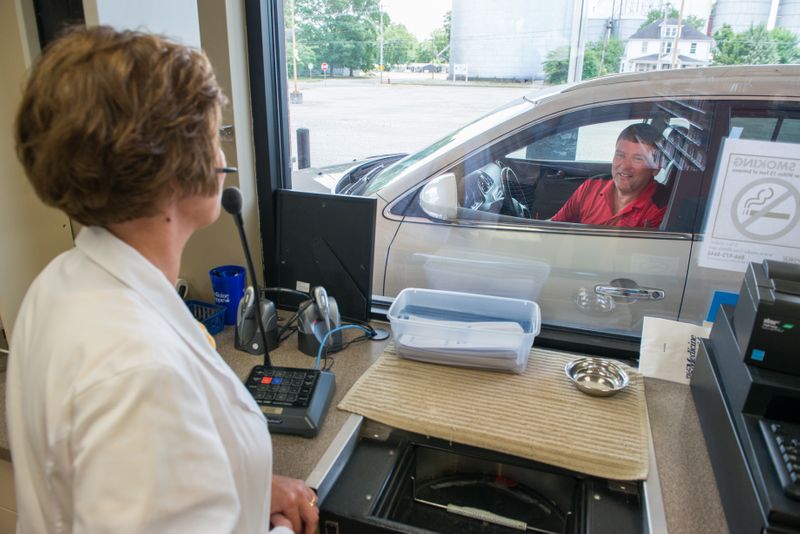 Pharmacy team member assisting a patient at the drive-up window